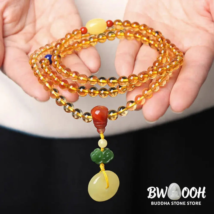 BWOOOH 108 Mala Beads bracelet featuring polished natural citrine, golden amber, and deep red agate, interspersed with a round peace buckle and a detailed gold-toned PiXiu charm on premium elastic string for wealth attraction and emotional balance. - View 5