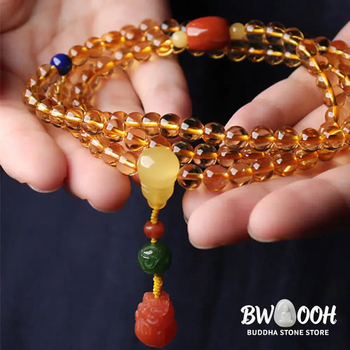 BWOOOH 108 Mala Beads bracelet featuring polished natural citrine, golden amber, and deep red agate, interspersed with a round peace buckle and a detailed gold-toned PiXiu charm on premium elastic string for wealth attraction and emotional balance. - View 20