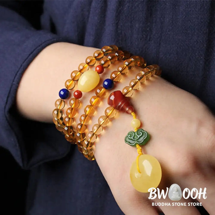 BWOOOH 108 Mala Beads bracelet featuring polished natural citrine, golden amber, and deep red agate, interspersed with a round peace buckle and a detailed gold-toned PiXiu charm on premium elastic string for wealth attraction and emotional balance. - View 3