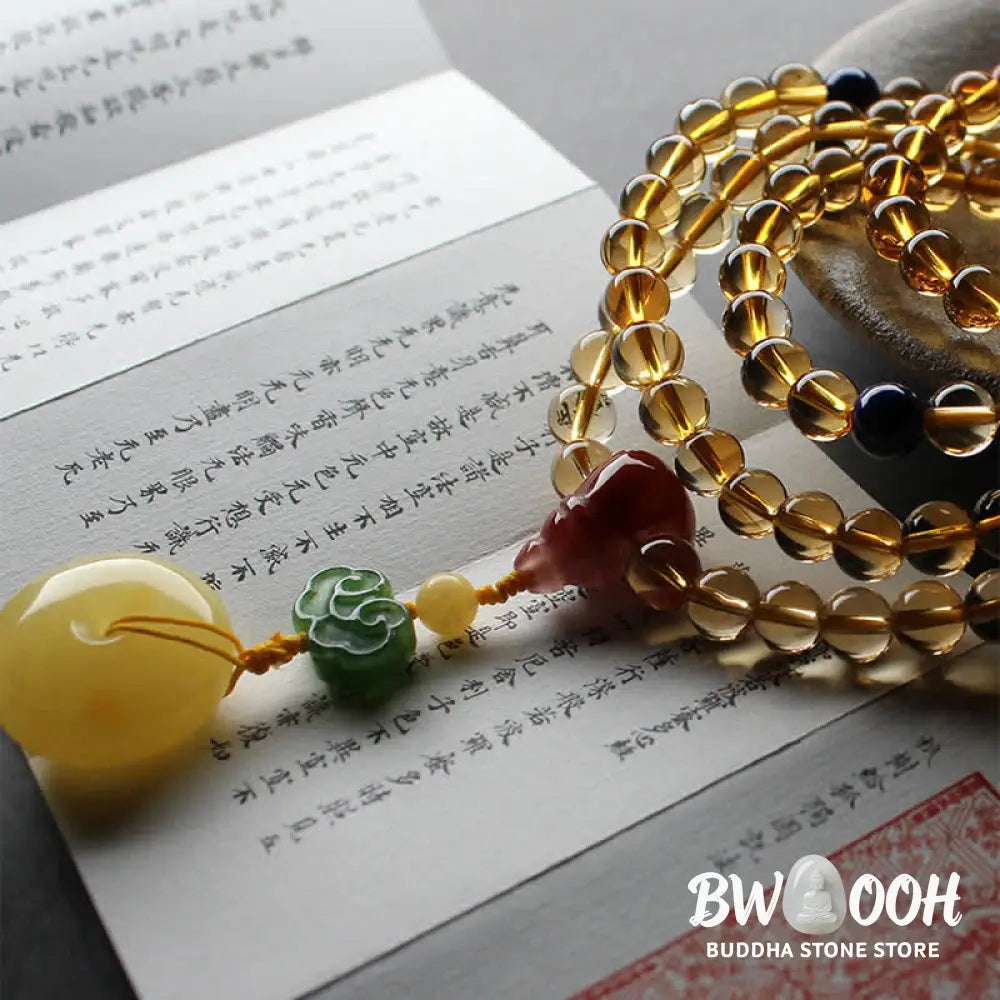 BWOOOH 108 Mala Beads bracelet featuring polished natural citrine, golden amber, and deep red agate, interspersed with a round peace buckle and a detailed gold-toned PiXiu charm on premium elastic string for wealth attraction and emotional balance. - View 15