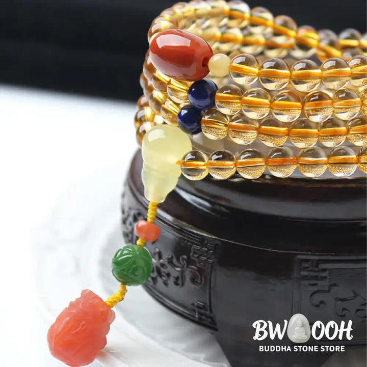 BWOOOH 108 Mala Beads bracelet featuring polished natural citrine, golden amber, and deep red agate, interspersed with a round peace buckle and a detailed gold-toned PiXiu charm on premium elastic string for wealth attraction and emotional balance. - View 21