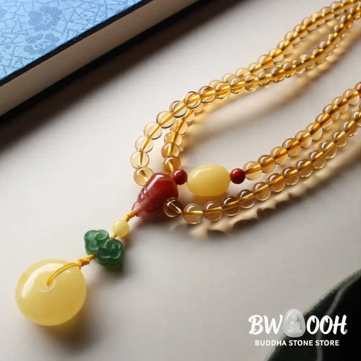 BWOOOH 108 Mala Beads bracelet featuring polished natural citrine, golden amber, and deep red agate, interspersed with a round peace buckle and a detailed gold-toned PiXiu charm on premium elastic string for wealth attraction and emotional balance. - View 12