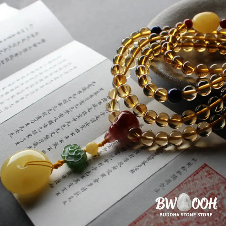 BWOOOH 108 Mala Beads bracelet featuring polished natural citrine, golden amber, and deep red agate, interspersed with a round peace buckle and a detailed gold-toned PiXiu charm on premium elastic string for wealth attraction and emotional balance. - View 9