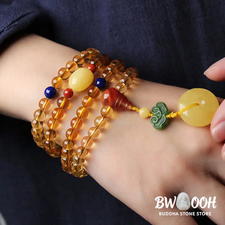 BWOOOH 108 Mala Beads bracelet featuring polished natural citrine, golden amber, and deep red agate, interspersed with a round peace buckle and a detailed gold-toned PiXiu charm on premium elastic string for wealth attraction and emotional balance. - View 4