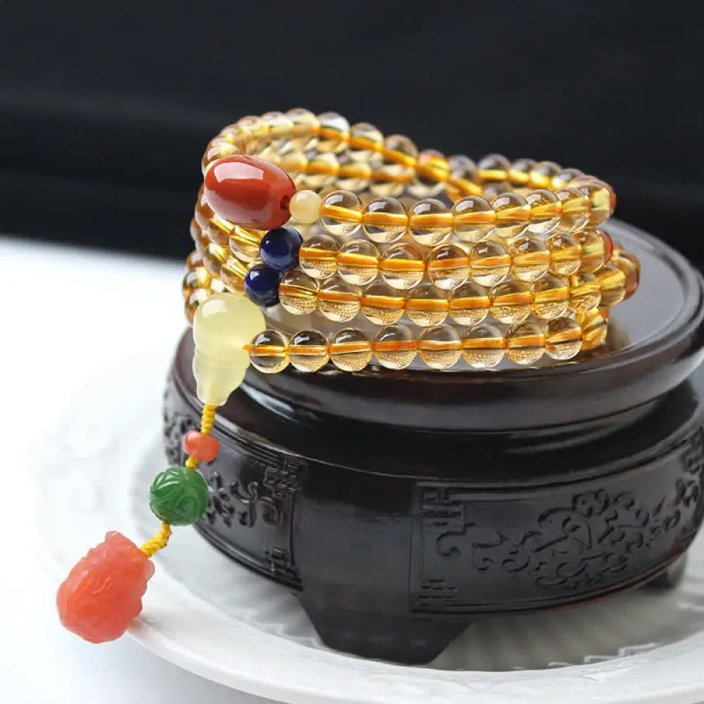 BWOOOH 108 Mala Beads bracelet featuring polished natural citrine, golden amber, and deep red agate, interspersed with a round peace buckle and a detailed gold-toned PiXiu charm on premium elastic string for wealth attraction and emotional balance. - View 18