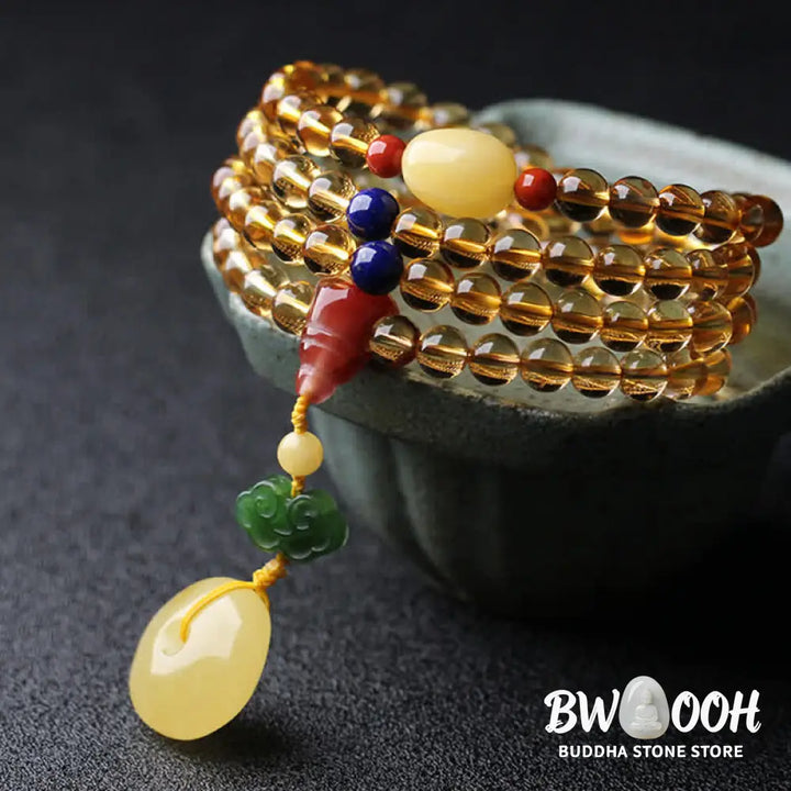 BWOOOH 108 Mala Beads bracelet featuring polished natural citrine, golden amber, and deep red agate, interspersed with a round peace buckle and a detailed gold-toned PiXiu charm on premium elastic string for wealth attraction and emotional balance. - View 11