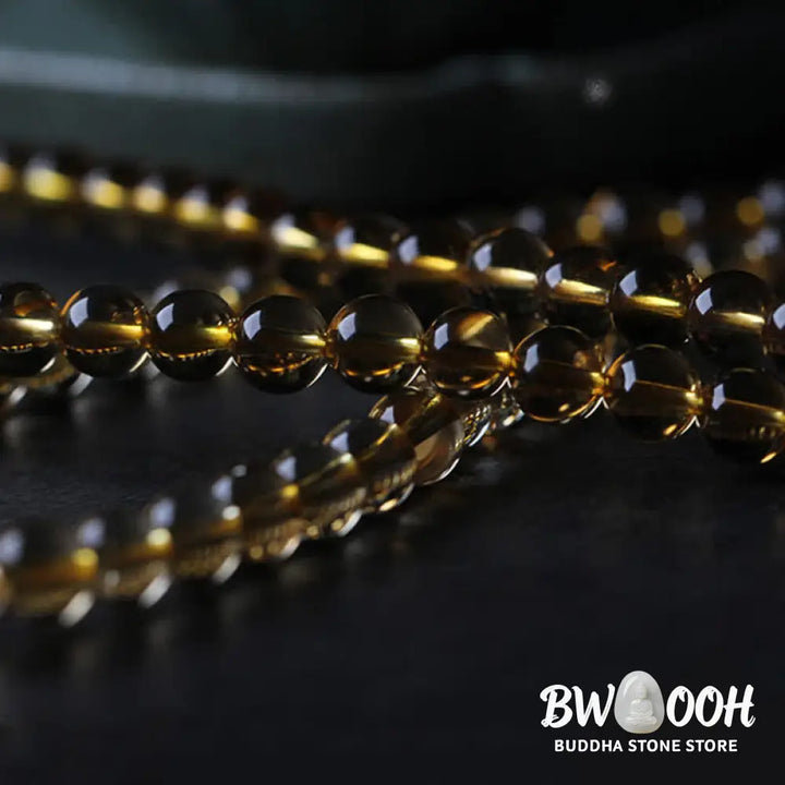 BWOOOH 108 Mala Beads bracelet featuring polished natural citrine, golden amber, and deep red agate, interspersed with a round peace buckle and a detailed gold-toned PiXiu charm on premium elastic string for wealth attraction and emotional balance. - View 17