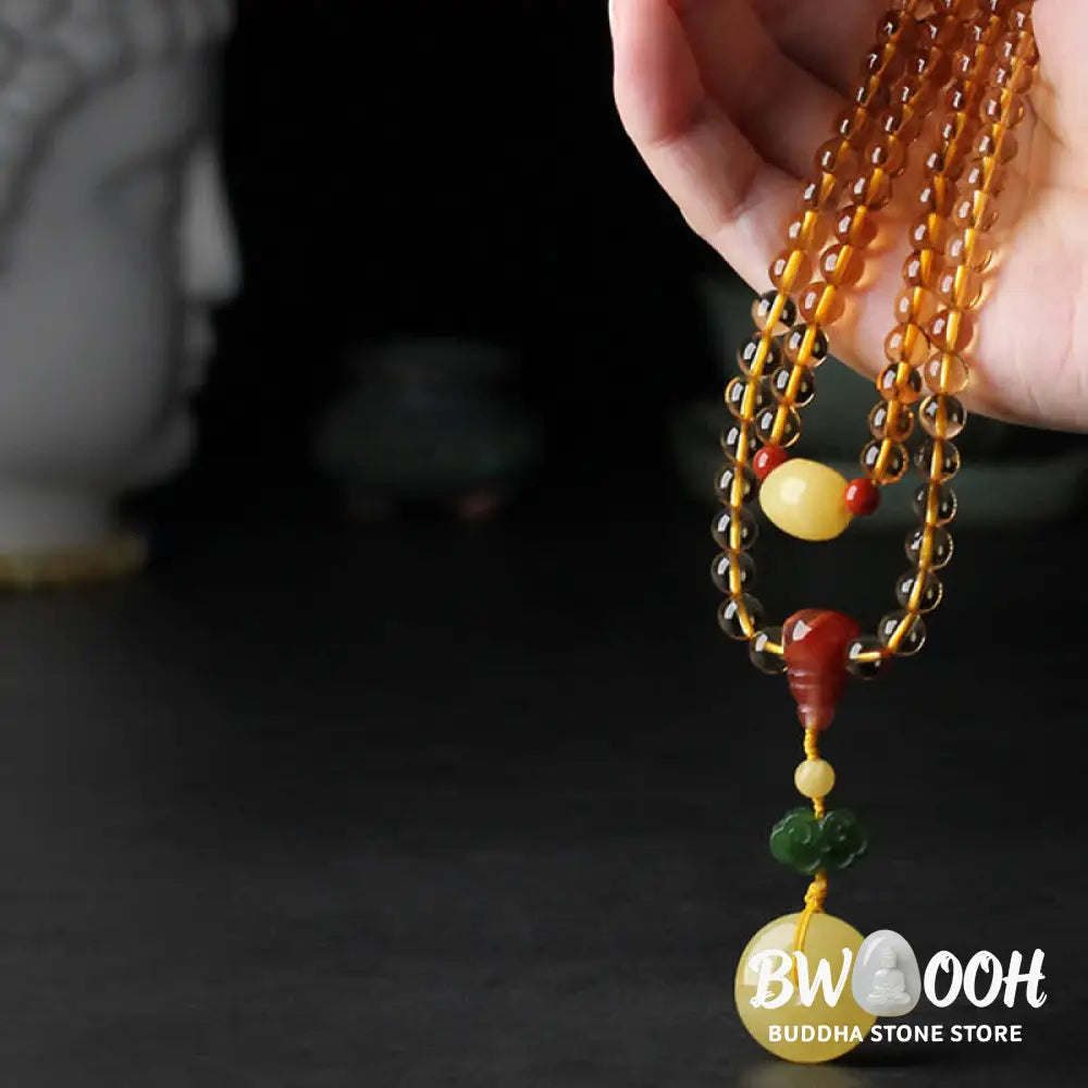 BWOOOH 108 Mala Beads bracelet featuring polished natural citrine, golden amber, and deep red agate, interspersed with a round peace buckle and a detailed gold-toned PiXiu charm on premium elastic string for wealth attraction and emotional balance. - View 6