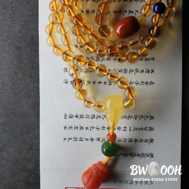 BWOOOH 108 Mala Beads bracelet featuring polished natural citrine, golden amber, and deep red agate, interspersed with a round peace buckle and a detailed gold-toned PiXiu charm on premium elastic string for wealth attraction and emotional balance. - View 22