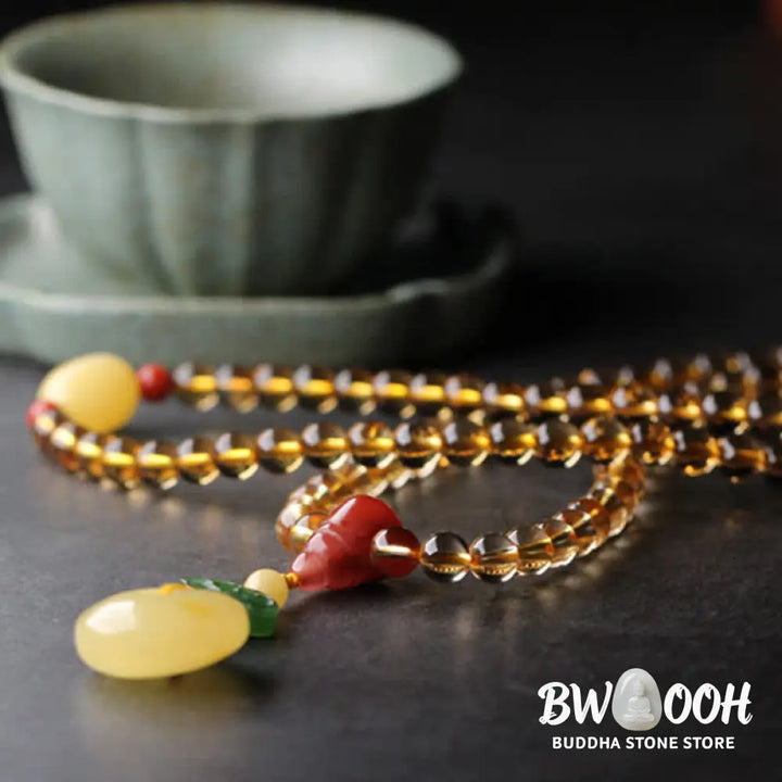 BWOOOH 108 Mala Beads bracelet featuring polished natural citrine, golden amber, and deep red agate, interspersed with a round peace buckle and a detailed gold-toned PiXiu charm on premium elastic string for wealth attraction and emotional balance. - View 14