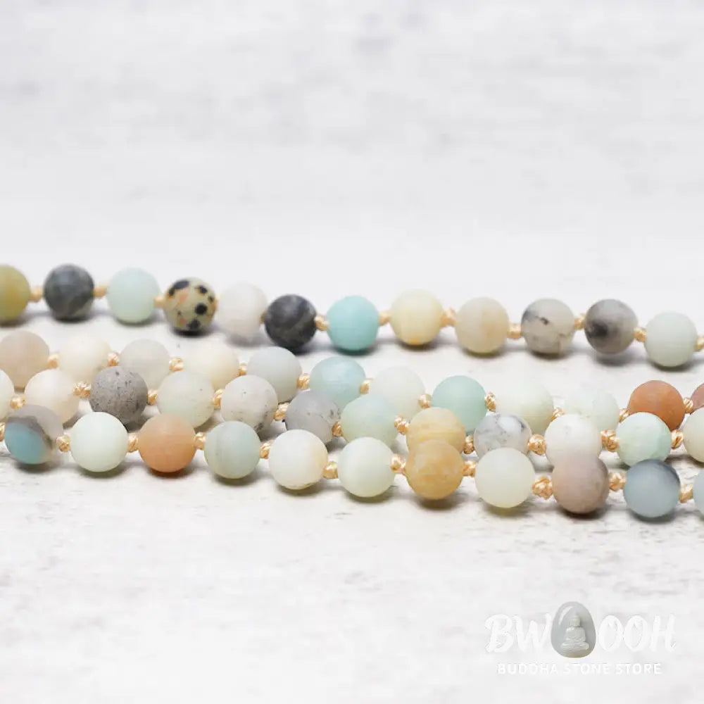 BWOOOH 108 Amazonite Beads Tassel Mala Bracelet on a natural wooden surface, showcasing its serene 6mm blue-green amazonite beads and an intricately woven tassel, reflecting spiritual balance and mindfulness. - View 4
