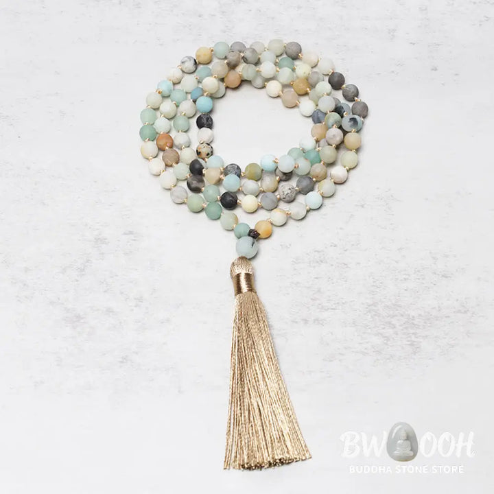 BWOOOH 108 Amazonite Beads Tassel Mala Bracelet on a natural wooden surface, showcasing its serene 6mm blue-green amazonite beads and an intricately woven tassel, reflecting spiritual balance and mindfulness. - View 2