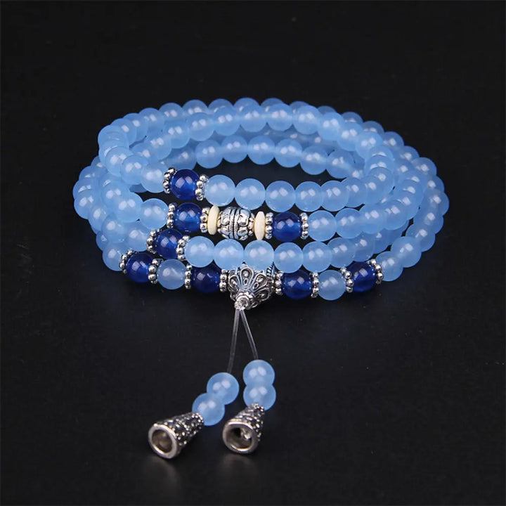 A BWOOOH 108-bead Blue Crystal Healing Mala Bracelet, featuring shimmering 6mm blue crystal beads, styled as a versatile bracelet and necklace. The natural variations in the blue crystals are visible, emphasizing its serene and handcrafted quality, perfect for meditation and spiritual balance.