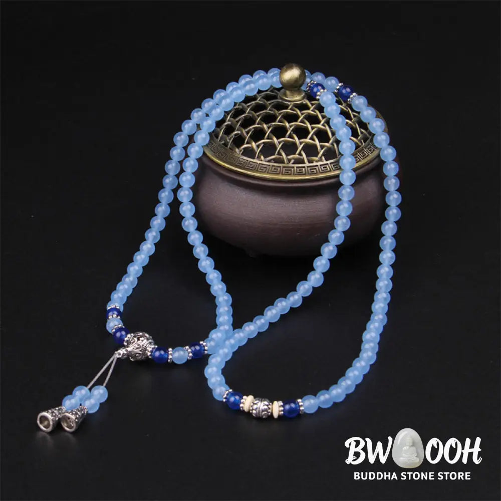A BWOOOH 108-bead Blue Crystal Healing Mala Bracelet, featuring shimmering 6mm blue crystal beads, styled as a versatile bracelet and necklace. The natural variations in the blue crystals are visible, emphasizing its serene and handcrafted quality, perfect for meditation and spiritual balance. - View 3