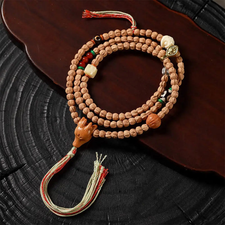 BWOOOH 108-bead Wisdom Mala bracelet featuring natural dark Bodhi Seeds, vibrant red agate beads, and a detailed deer head charm, displayed on a serene background, perfect for meditation and spiritual balance.