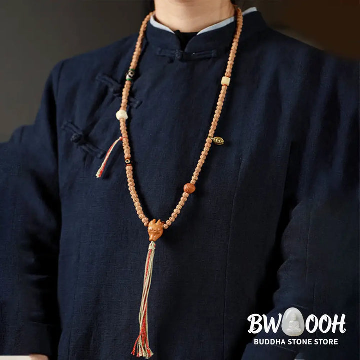 BWOOOH 108-bead Wisdom Mala bracelet featuring natural dark Bodhi Seeds, vibrant red agate beads, and a detailed deer head charm, displayed on a serene background, perfect for meditation and spiritual balance. - View 3