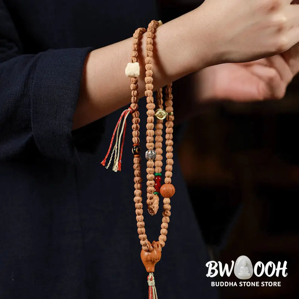 BWOOOH 108-bead Wisdom Mala bracelet featuring natural dark Bodhi Seeds, vibrant red agate beads, and a detailed deer head charm, displayed on a serene background, perfect for meditation and spiritual balance. - View 9