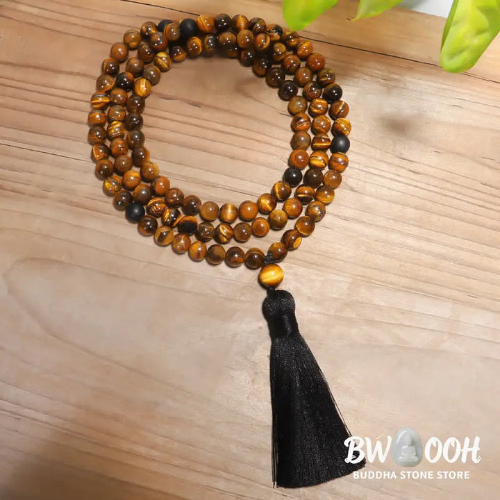 A BWOOOH 108-bead Tiger Eye protection mala bracelet with a matching tassel, showcased on a wrist for meditation and daily spiritual practice, emphasizing courage and positive energy. - View 8