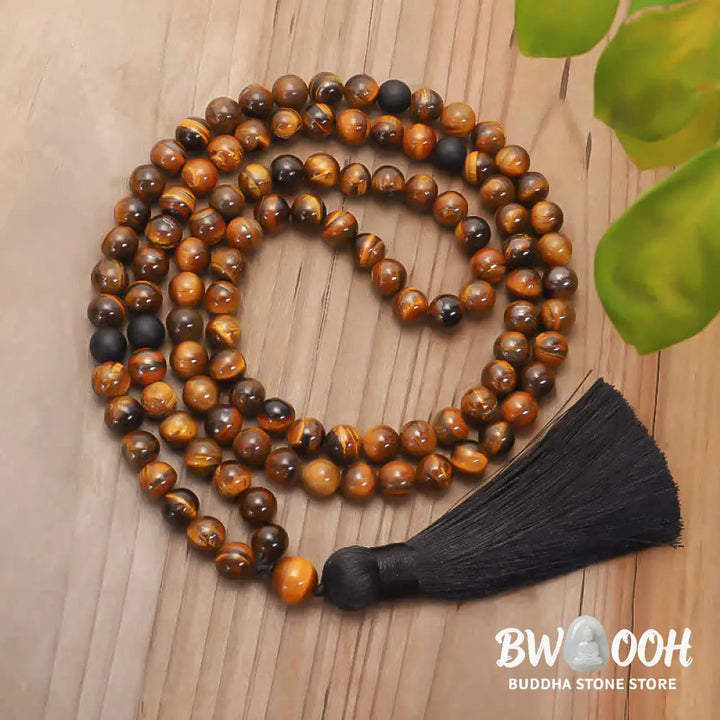 A BWOOOH 108-bead Tiger Eye protection mala bracelet with a matching tassel, showcased on a wrist for meditation and daily spiritual practice, emphasizing courage and positive energy. - View 9