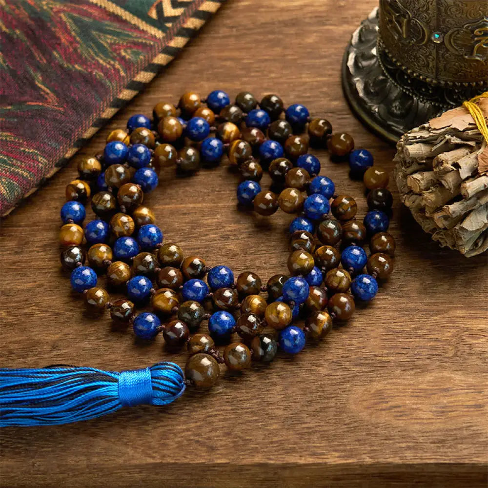 BWOOOH 108-bead mala bracelet featuring polished brown Tiger Eye and deep blue Lazurite Lapis Lazuli stones with a traditional tassel, symbolizing protection and wisdom for mindfulness.