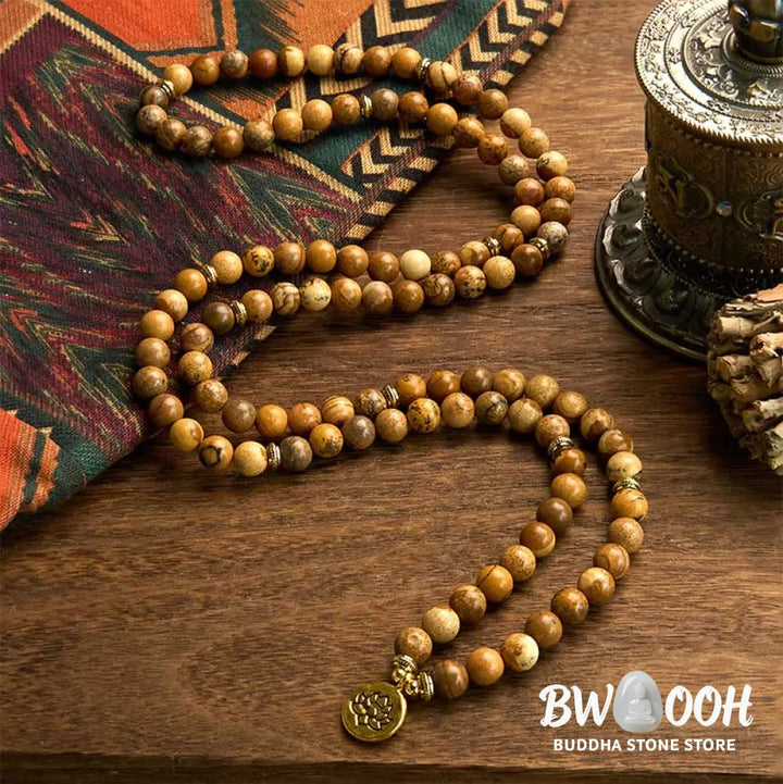 Close-up of BWOOOH 108-bead Picture Jasper Mala bracelet with earthy-toned, 8mm beads and a delicate round lotus-engraved charm, signifying courage and spiritual grounding for meditation. - View 2
