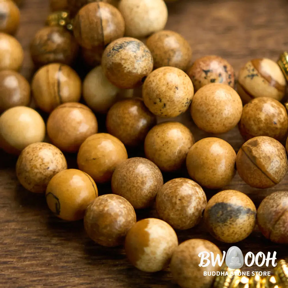 Close-up of BWOOOH 108-bead Picture Jasper Mala bracelet with earthy-toned, 8mm beads and a delicate round lotus-engraved charm, signifying courage and spiritual grounding for meditation. - View 6