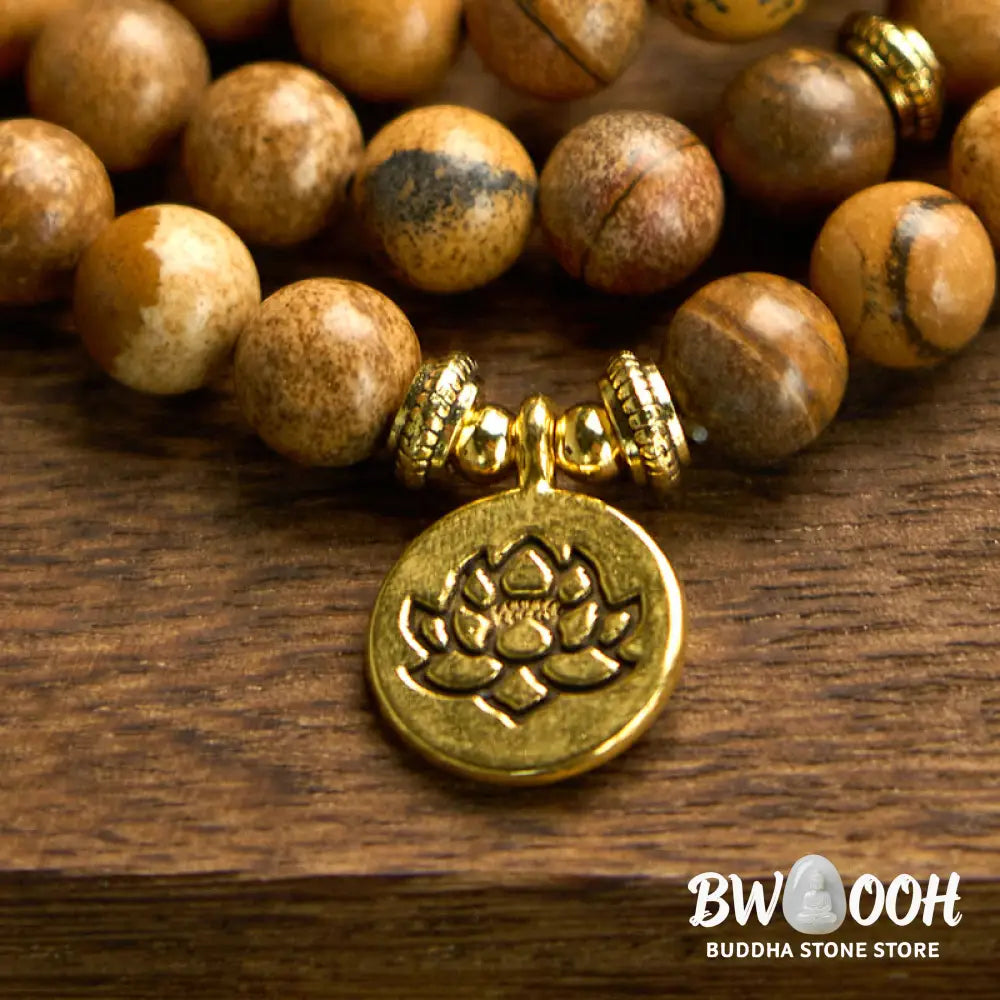 Close-up of BWOOOH 108-bead Picture Jasper Mala bracelet with earthy-toned, 8mm beads and a delicate round lotus-engraved charm, signifying courage and spiritual grounding for meditation. - View 7