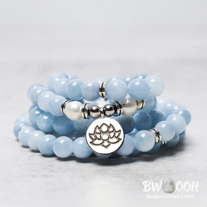 A close-up of the BWOOOH 108-bead Aquamarine Mala healing bracelet, featuring hand-grinded 8mm blue aquamarine crystals, aesthetic circle spacers, and a central aluminum lotus engraving, designed for meditation and spiritual balance. - View 3