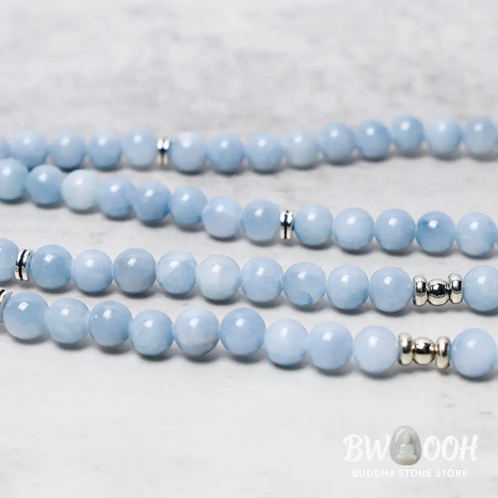 A close-up of the BWOOOH 108-bead Aquamarine Mala healing bracelet, featuring hand-grinded 8mm blue aquamarine crystals, aesthetic circle spacers, and a central aluminum lotus engraving, designed for meditation and spiritual balance. - View 4