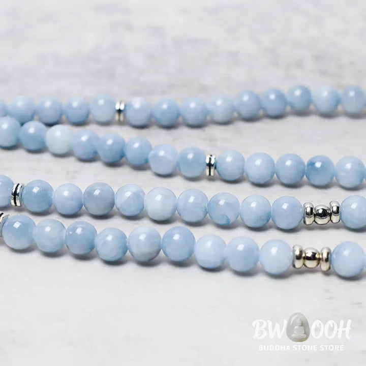 A close-up of the BWOOOH 108-bead Aquamarine Mala healing bracelet, featuring hand-grinded 8mm blue aquamarine crystals, aesthetic circle spacers, and a central aluminum lotus engraving, designed for meditation and spiritual balance. - View 4