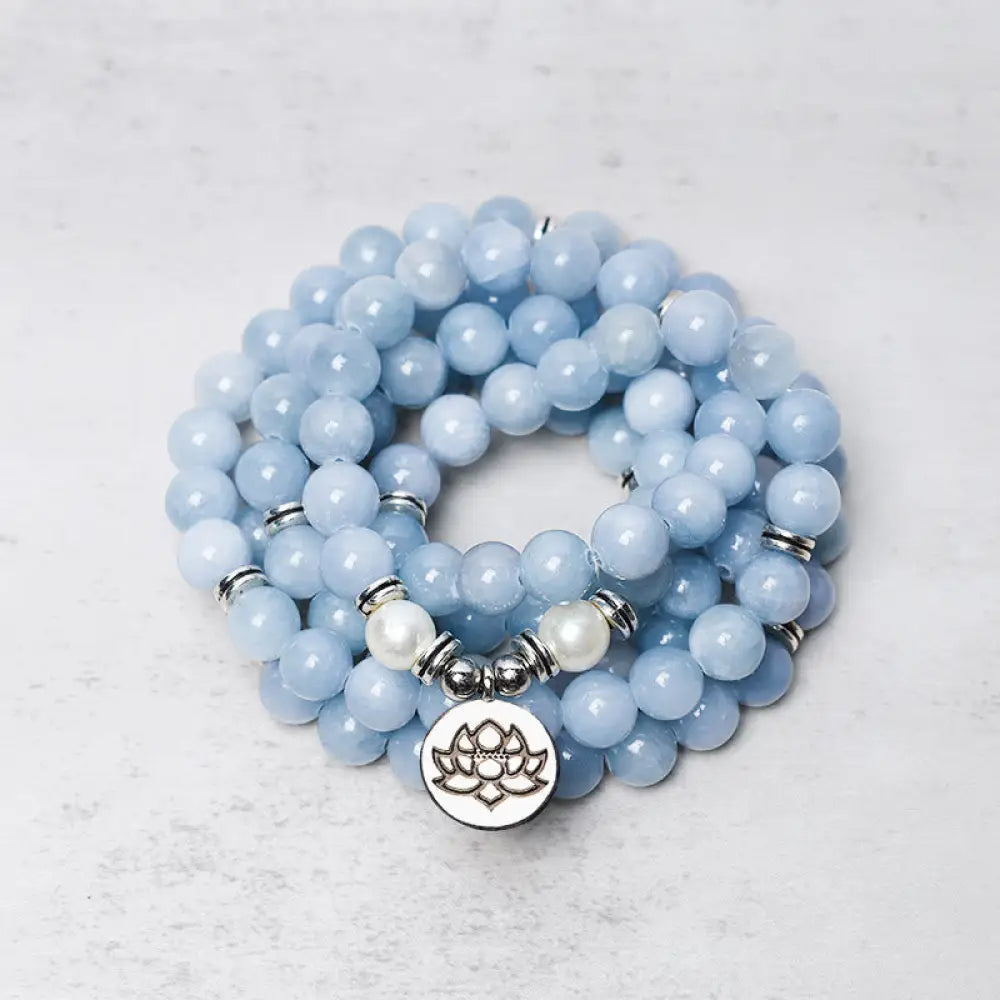 A close-up of the BWOOOH 108-bead Aquamarine Mala healing bracelet, featuring hand-grinded 8mm blue aquamarine crystals, aesthetic circle spacers, and a central aluminum lotus engraving, designed for meditation and spiritual balance.