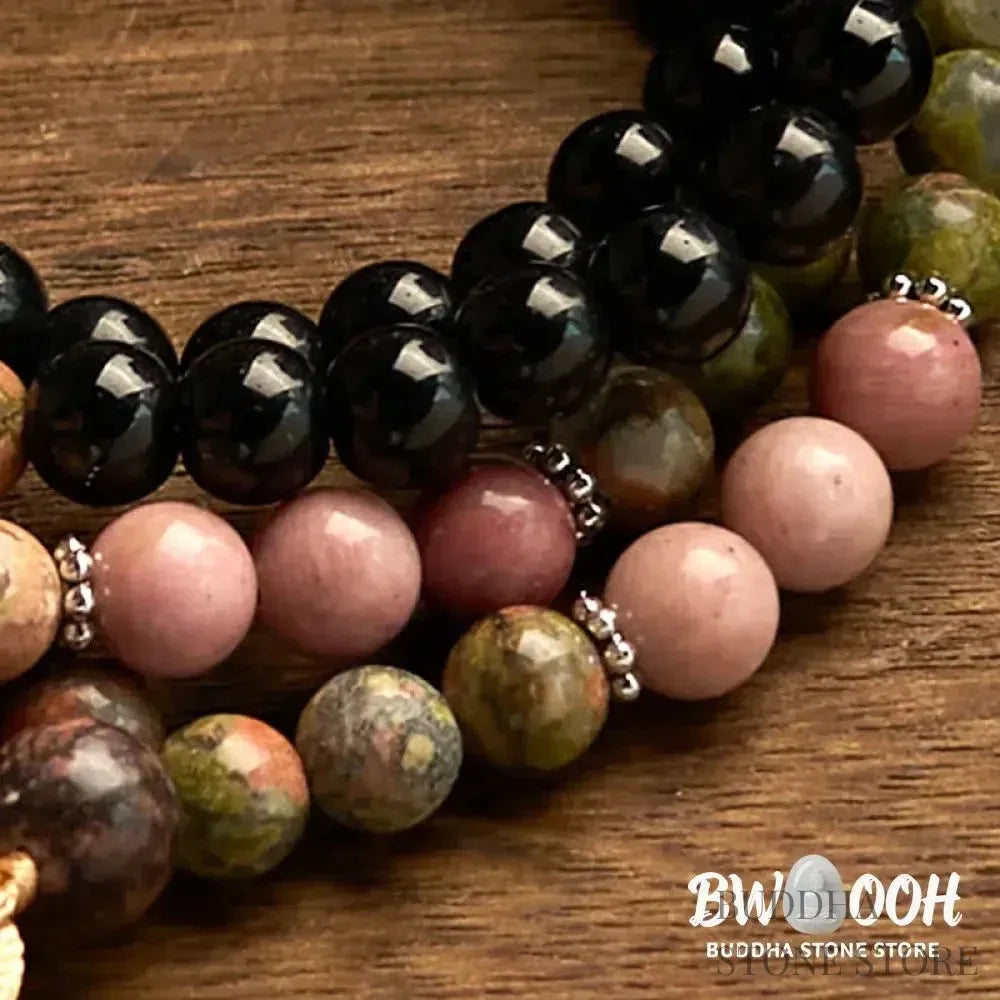 BWOOOH 108 Mala Beads crafted from Black Jasper and Rhodonite with a khaki tassel, resting on a meditation cushion, symbolizing grounding and emotional healing. - View 7