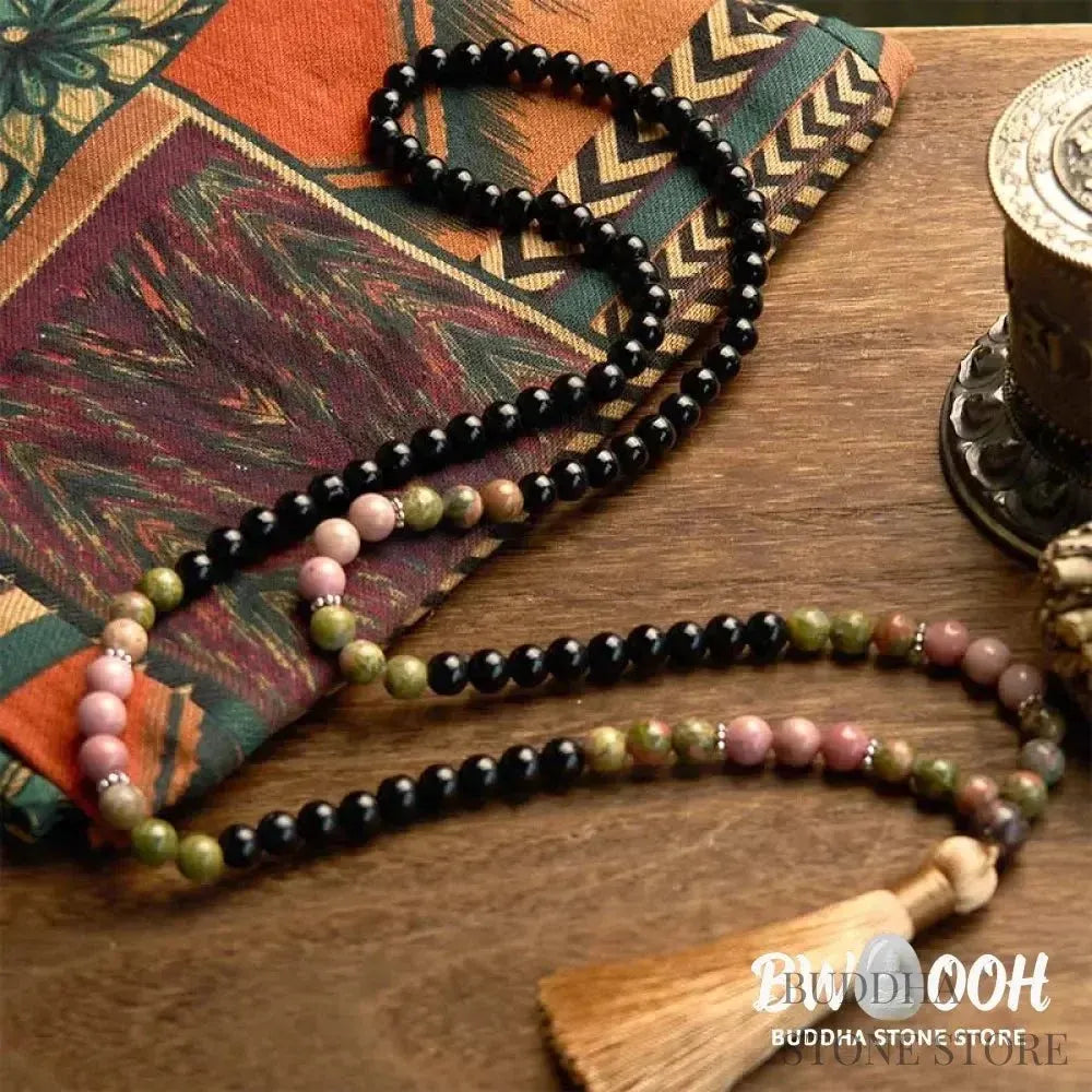 BWOOOH 108 Mala Beads crafted from Black Jasper and Rhodonite with a khaki tassel, resting on a meditation cushion, symbolizing grounding and emotional healing. - View 6