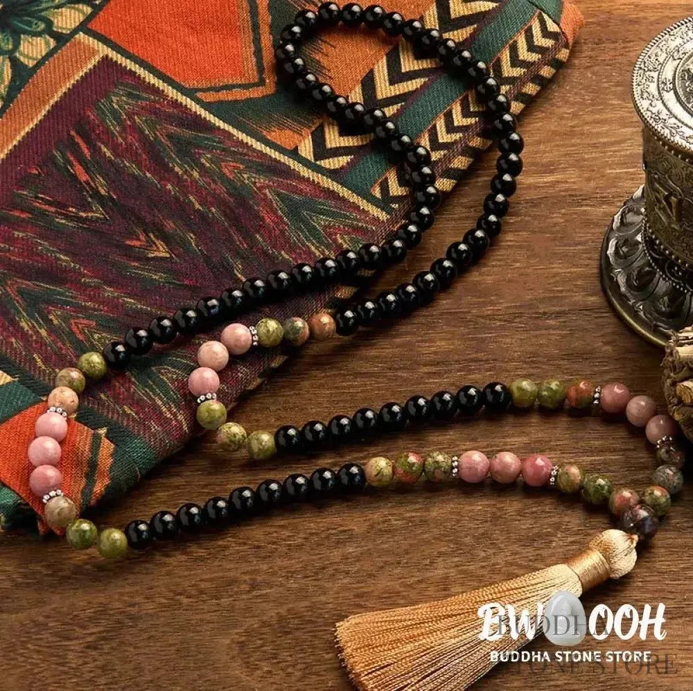 BWOOOH 108 Mala Beads crafted from Black Jasper and Rhodonite with a khaki tassel, resting on a meditation cushion, symbolizing grounding and emotional healing. - View 2