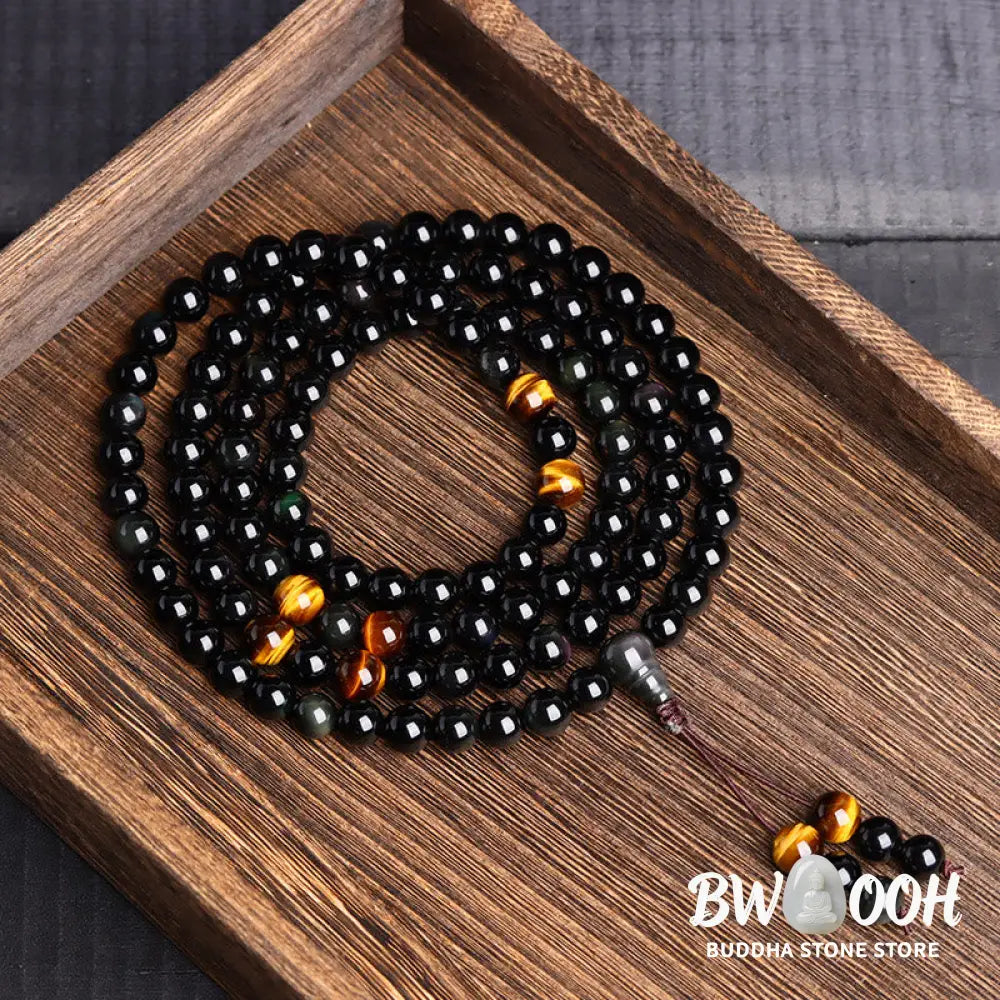 BWOOOH 108 Mala Beads crafted from polished Black Obsidian and shimmering Ice Obsidian, symbolizing energy protection and inner fulfillment, designed for meditation and mindfulness, photographed on a serene, textured surface. - View 4