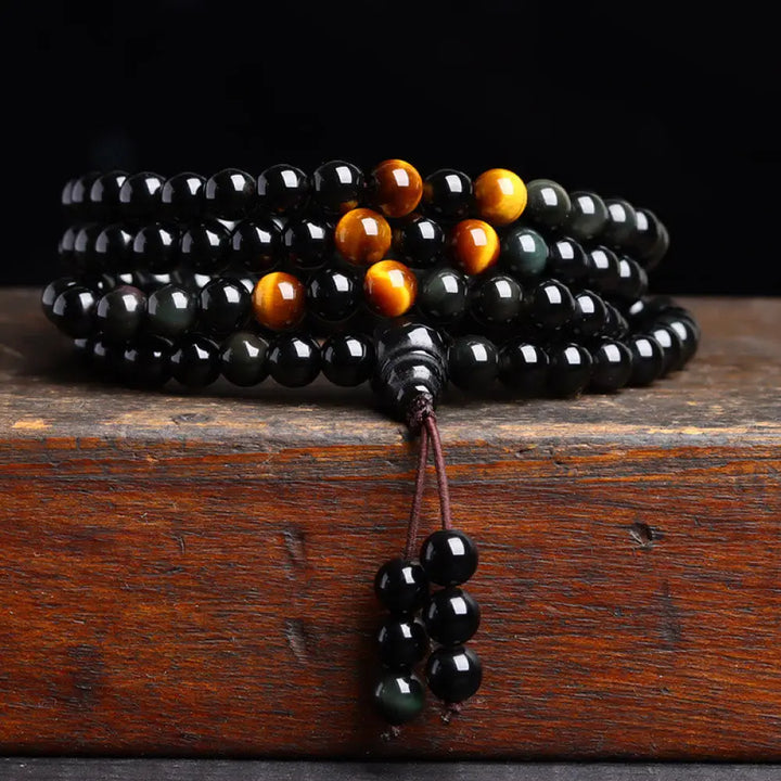 BWOOOH 108 Mala Beads crafted from polished Black Obsidian and shimmering Ice Obsidian, symbolizing energy protection and inner fulfillment, designed for meditation and mindfulness, photographed on a serene, textured surface. - View 2