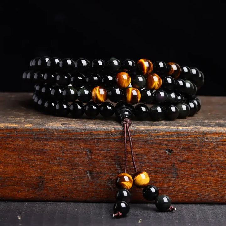 BWOOOH 108 Mala Beads crafted from polished Black Obsidian and shimmering Ice Obsidian, symbolizing energy protection and inner fulfillment, designed for meditation and mindfulness, photographed on a serene, textured surface. - View 3
