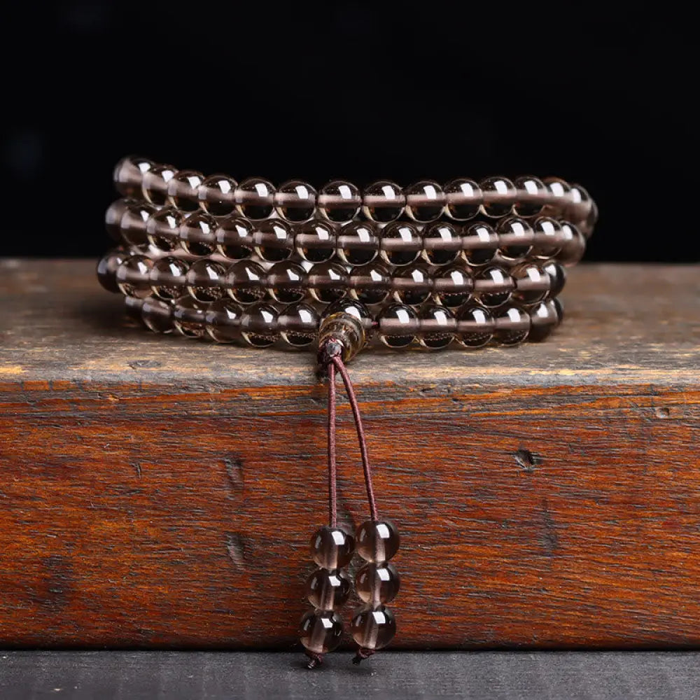 BWOOOH 108 Mala Beads crafted from polished Black Obsidian and shimmering Ice Obsidian, symbolizing energy protection and inner fulfillment, designed for meditation and mindfulness, photographed on a serene, textured surface. - View 11
