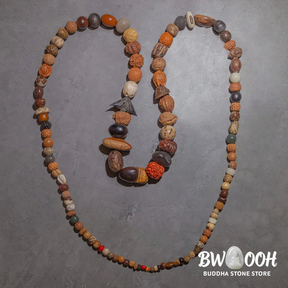 A close-up of the BWOOOH 108 Bodhi Seed Mala Bracelet, showcasing naturally varied seeds, a prominent guru bead, and a delicate lotus tassel, arranged for meditation or wrist wear. - View 4
