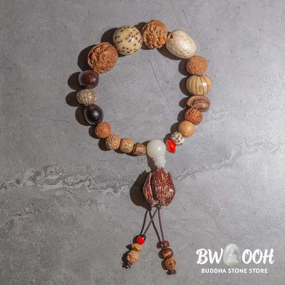 A close-up of the BWOOOH 108 Bodhi Seed Mala Bracelet, showcasing naturally varied seeds, a prominent guru bead, and a delicate lotus tassel, arranged for meditation or wrist wear. - View 7