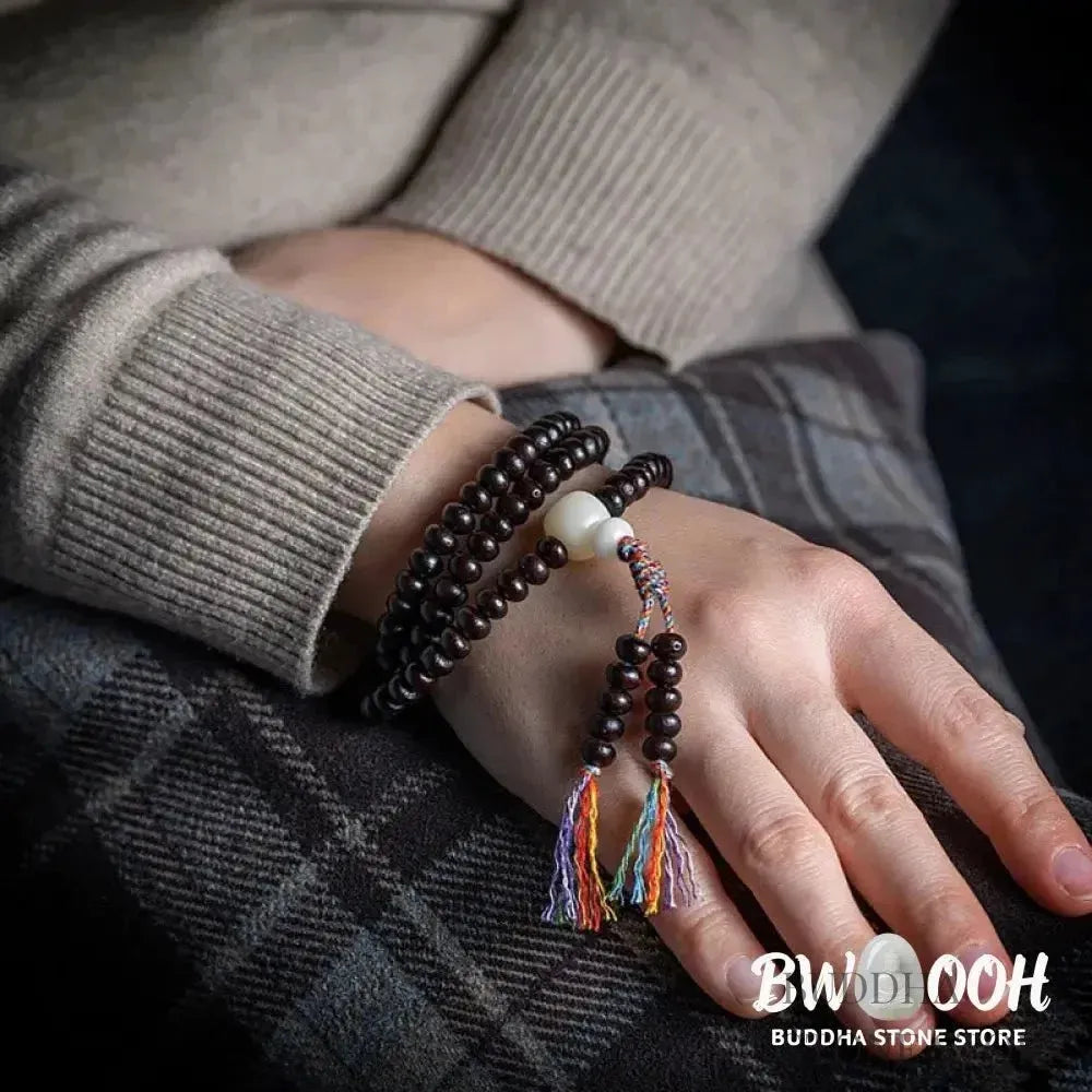 A close-up of the BWOOOH 108 Mala Bracelet, showcasing polished red Bowl Bodhi seeds, each with a distinct &