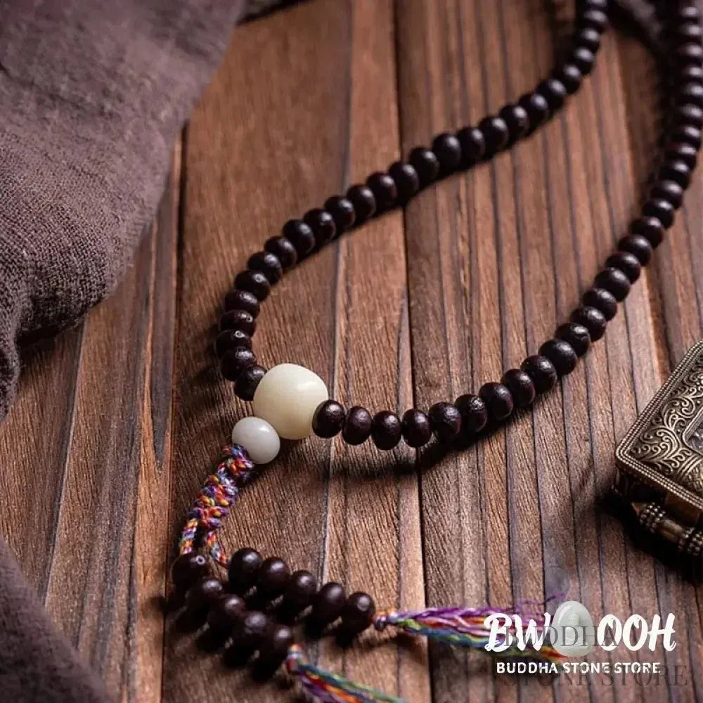A close-up of the BWOOOH 108 Mala Bracelet, showcasing polished red Bowl Bodhi seeds, each with a distinct &