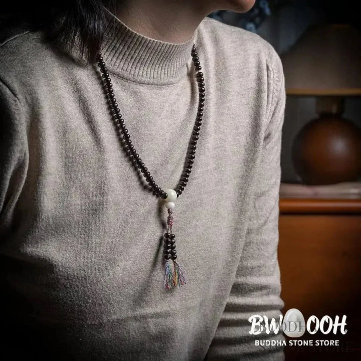 A close-up of the BWOOOH 108 Mala Bracelet, showcasing polished red Bowl Bodhi seeds, each with a distinct &