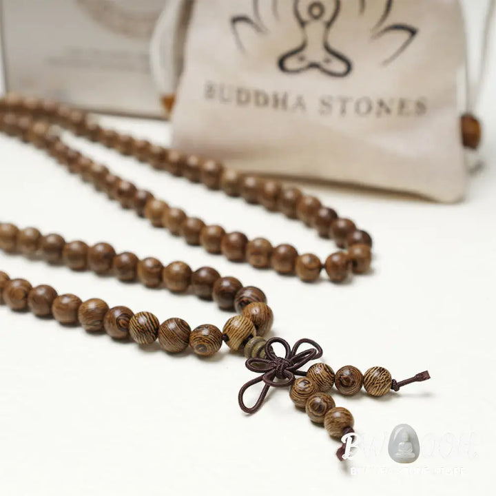 A close-up of the BWOOOH 108 mala beads bracelet, showcasing smooth, aromatic sandalwood interspersed with dark ebony, rich rosewood, and stabilizing wenge wood. The elastic design highlights the natural wood grain, perfect for meditation, prayer, and achieving daily spiritual balance. - View 19