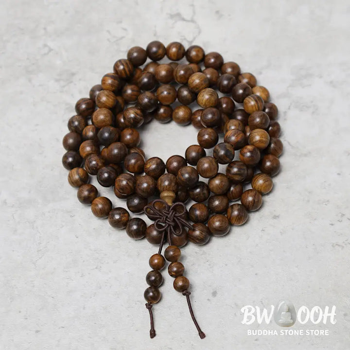 A close-up of the BWOOOH 108 mala beads bracelet, showcasing smooth, aromatic sandalwood interspersed with dark ebony, rich rosewood, and stabilizing wenge wood. The elastic design highlights the natural wood grain, perfect for meditation, prayer, and achieving daily spiritual balance. - View 3
