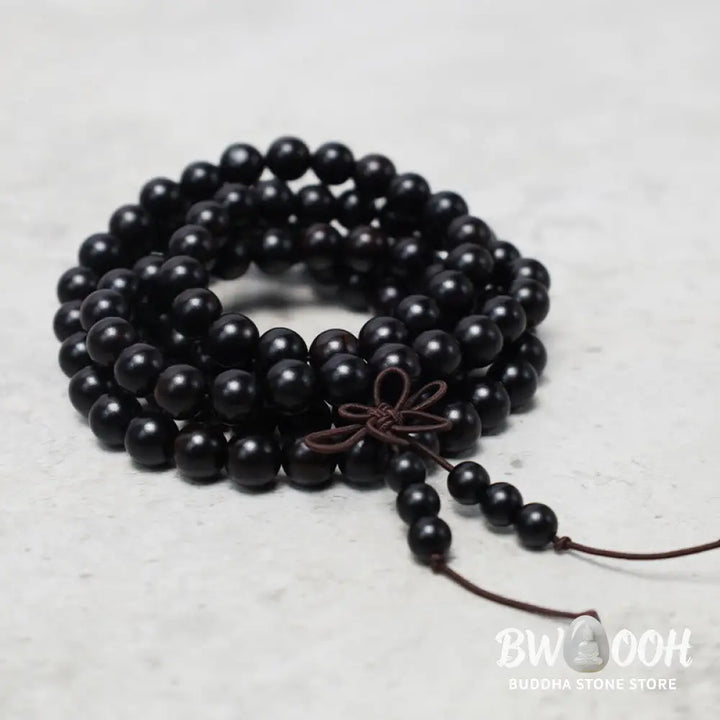 A close-up of the BWOOOH 108 mala beads bracelet, showcasing smooth, aromatic sandalwood interspersed with dark ebony, rich rosewood, and stabilizing wenge wood. The elastic design highlights the natural wood grain, perfect for meditation, prayer, and achieving daily spiritual balance. - View 9