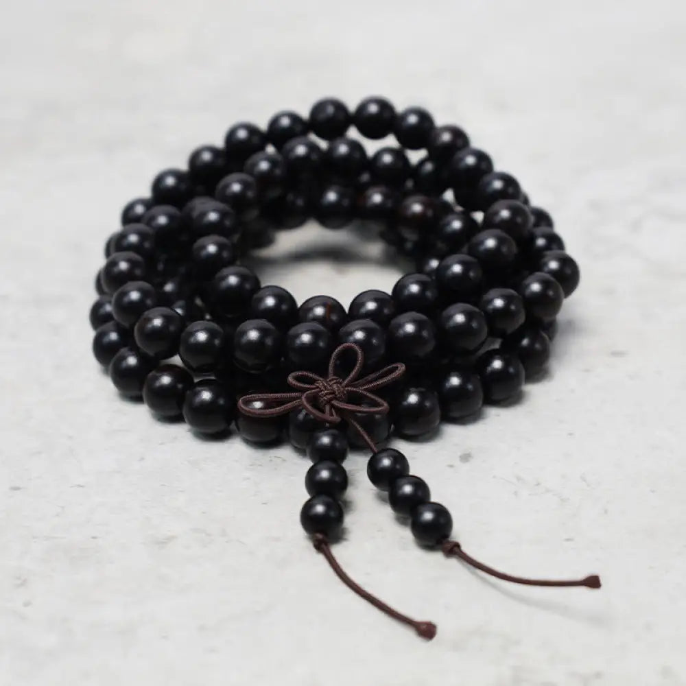 A close-up of the BWOOOH 108 mala beads bracelet, showcasing smooth, aromatic sandalwood interspersed with dark ebony, rich rosewood, and stabilizing wenge wood. The elastic design highlights the natural wood grain, perfect for meditation, prayer, and achieving daily spiritual balance. - View 8