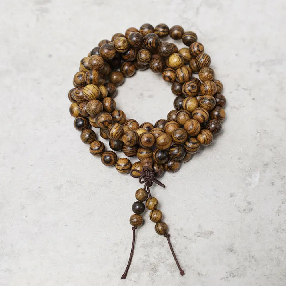 A close-up of the BWOOOH 108 mala beads bracelet, showcasing smooth, aromatic sandalwood interspersed with dark ebony, rich rosewood, and stabilizing wenge wood. The elastic design highlights the natural wood grain, perfect for meditation, prayer, and achieving daily spiritual balance. - View 21