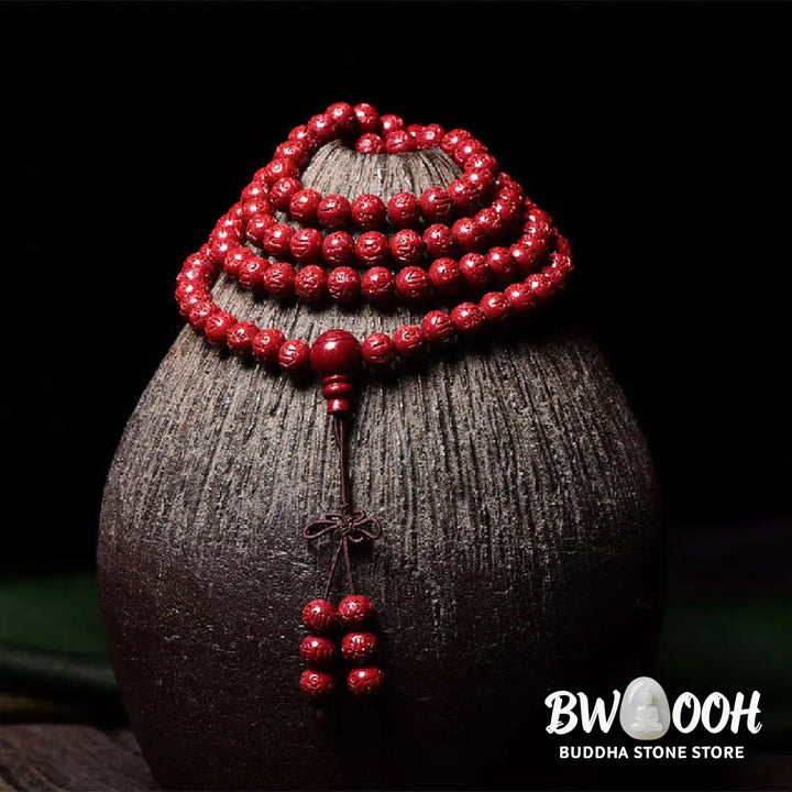 A BWOOOH Cinnabar 108 Mala Beads Blessing Bracelet, showcasing deeply engraved Om Mani Padme Hum mantra patterns on each bead, symbolizing spiritual protection and focus. - View 8