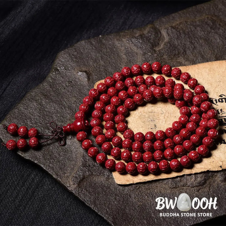 A BWOOOH Cinnabar 108 Mala Beads Blessing Bracelet, showcasing deeply engraved Om Mani Padme Hum mantra patterns on each bead, symbolizing spiritual protection and focus. - View 10